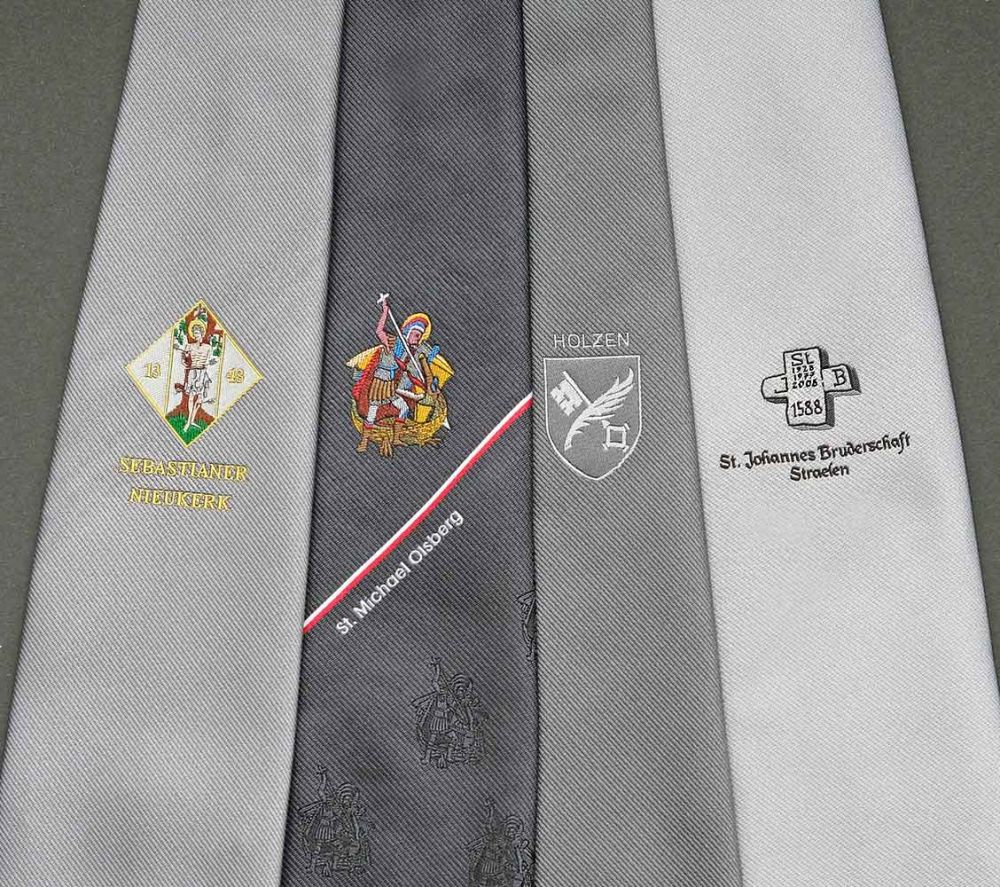 Schützenkrawatten in grauen Stoffen mit gewebtem Logos in Detailansicht
